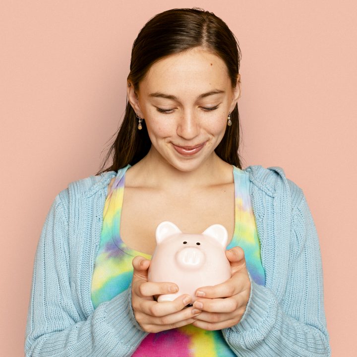 Beautiful woman holding piggy bank for financial savings campaign