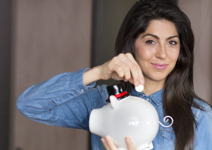 happy-girl-posing-with-her-piggy-bank